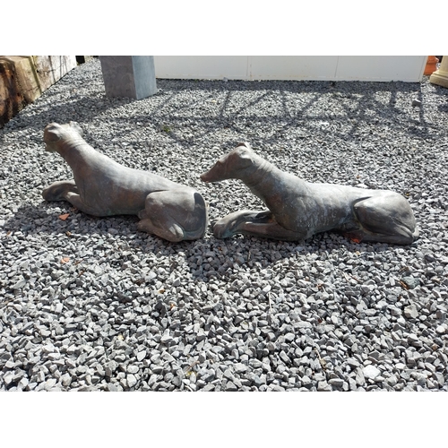 394 - Pair of painted moulded terracotta statues of recumbent Whippets {24 cm H x 60 cm W x 19 cm D}.