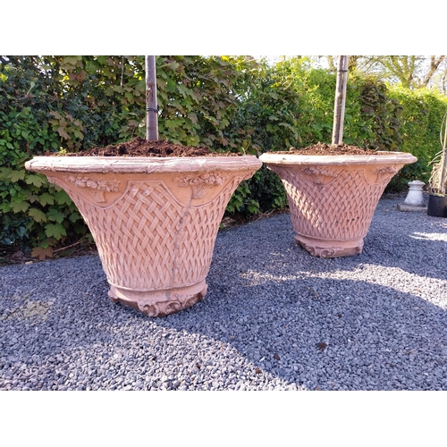 532 - Pair of moulded terracotta lattice urns with tree {Urn dimension 77 cm H x 105 cm Dia.}.