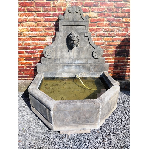 550 - Hand carved limestone wall fountain decorated with Ladies mask {172 cm H x 156 cm W x 127 cm D}.