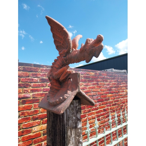 599 - Pair of moulded terracotta ridge tiles surmounted with Dragons {}.