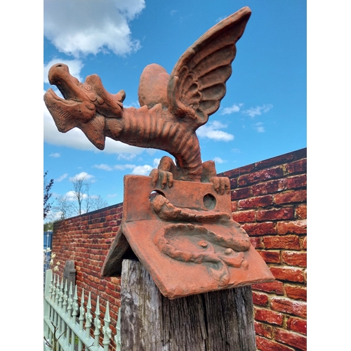 599 - Pair of moulded terracotta ridge tiles surmounted with Dragons {}.