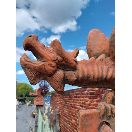 599 - Pair of moulded terracotta ridge tiles surmounted with Dragons {}.