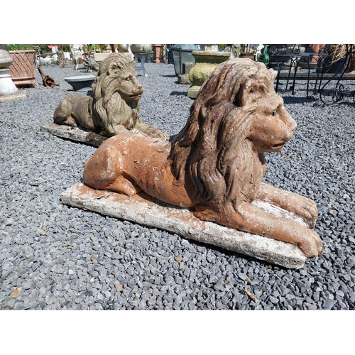 836 - Pair of re-constituted stone statues of recumbent Lions {50 cm H x 87 cm W x 31 cm D}.