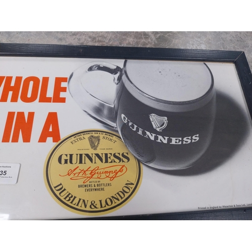 1235 - There's a Whole World in a Guinness framed showcard. {24 cm H x 49 cm W}.