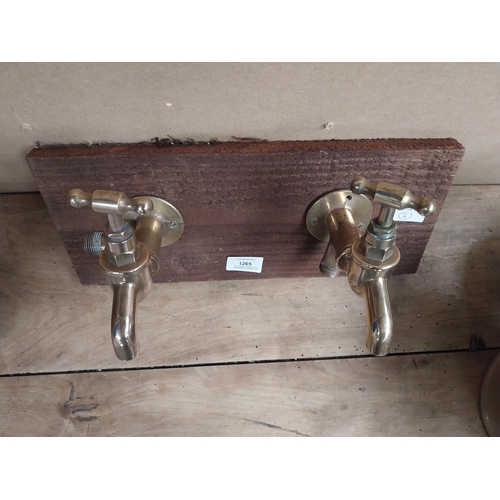 1265 - Pair of Brass taps mounted on wooden board. {14 cm H x 28 cm W}.