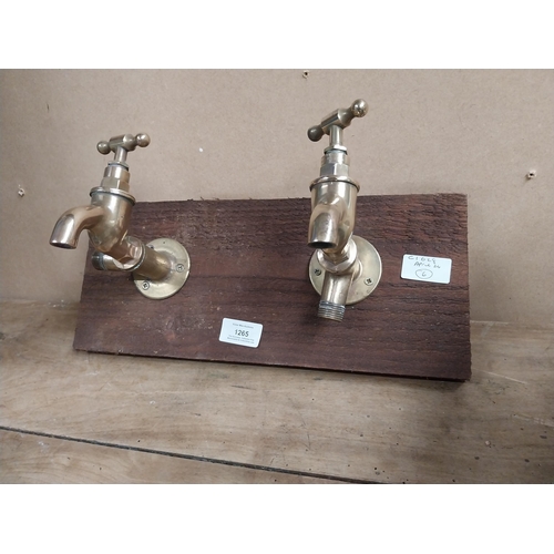 1265 - Pair of Brass taps mounted on wooden board. {14 cm H x 28 cm W}.