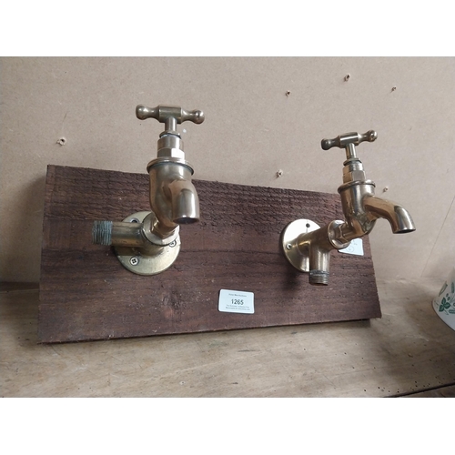 1265 - Pair of Brass taps mounted on wooden board. {14 cm H x 28 cm W}.