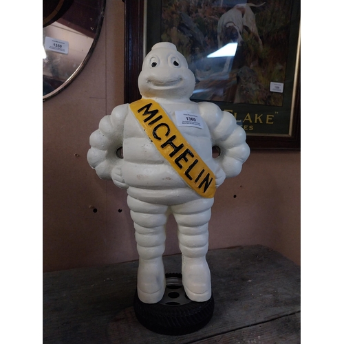 1369 - Cast iron Michelin Man on tyre stand. {39 cm H x 24 cm W x 14 cm D}.