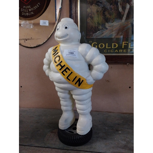 1369 - Cast iron Michelin Man on tyre stand. {39 cm H x 24 cm W x 14 cm D}.