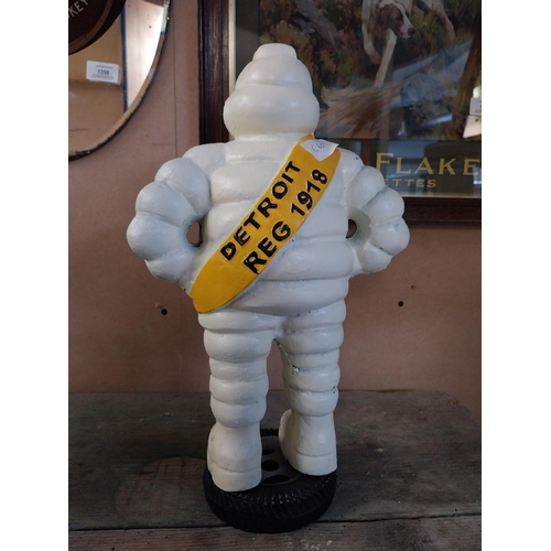 1369 - Cast iron Michelin Man on tyre stand. {39 cm H x 24 cm W x 14 cm D}.