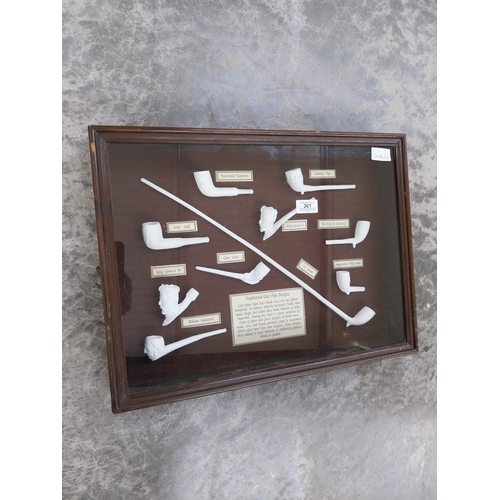 361 - Collection of Irish clay pipes in wooden and glazed display case. {29 cm H x 51 cm W x 8 cm D}.