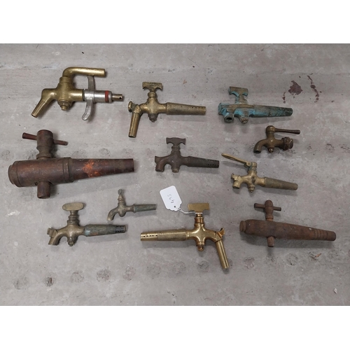 495 - Collection of nine 19th C. brass barrel taps and two wooden barrel taps.