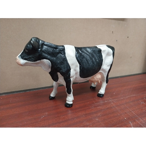 831 - Cast iron model of Freisian Cow. {20 cm H x 33 cm W x 9 cm D}.