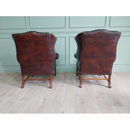 100 - Pair of good quality early 20th C. hand died cigar leather deep buttoned wing back chairs raised on ... 