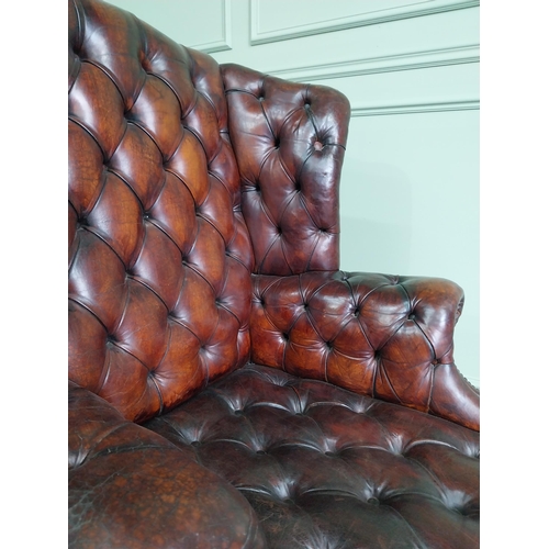 100 - Pair of good quality early 20th C. hand died cigar leather deep buttoned wing back chairs raised on ... 