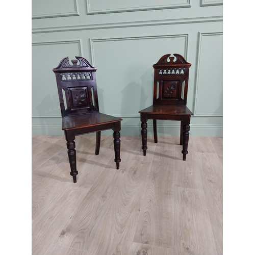 112 - Pair of Edwardian carved mahogany hall chairs raised on turned legs {88 cm H x 46 cm W x 40 cm D}.