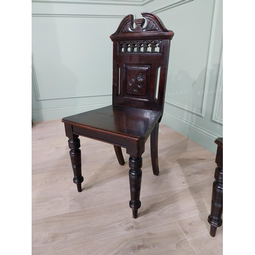 112 - Pair of Edwardian carved mahogany hall chairs raised on turned legs {88 cm H x 46 cm W x 40 cm D}.