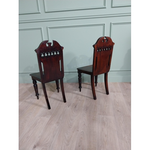 112 - Pair of Edwardian carved mahogany hall chairs raised on turned legs {88 cm H x 46 cm W x 40 cm D}.