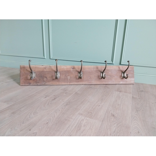 161 - Five good quality bronze coat hangers mounted on mahogany board {30 cm H x 145 cm W x 19 cm D}.