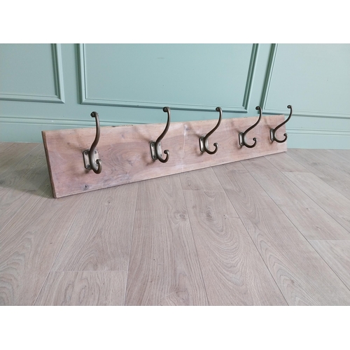 161 - Five good quality bronze coat hangers mounted on mahogany board {30 cm H x 145 cm W x 19 cm D}.