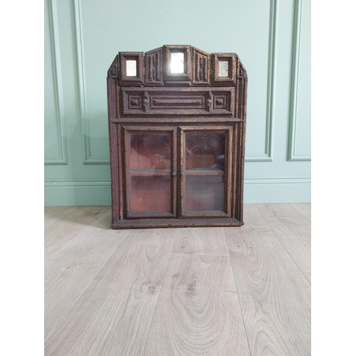 21 - Early 20th C. tramp art wall hanging cabinet with two glazed doors {70 cm H x 54 cm W x 23 cm D}.