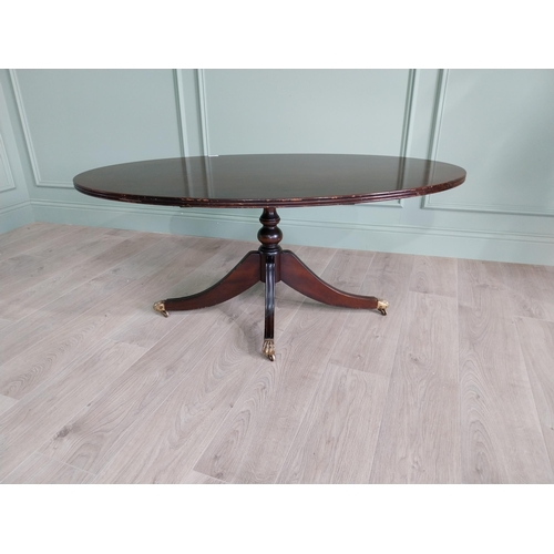 452 - Mahogany coffee table raised on turned column and three outswept legs and castors in the Regency sty... 