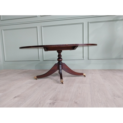 452 - Mahogany coffee table raised on turned column and three outswept legs and castors in the Regency sty... 