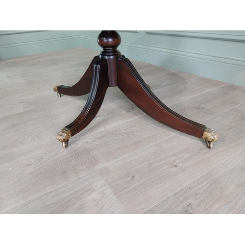 452 - Mahogany coffee table raised on turned column and three outswept legs and castors in the Regency sty... 