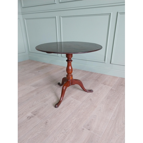 464 - Irish Georgian mahogany tilt top centre table raised on turned column and three outswept feet {68 cm... 