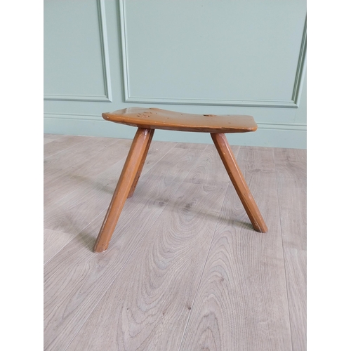 64 - 19th. C Irish painted elm three legged stool {35 cm H x 38 cm W x 26 cm D}.