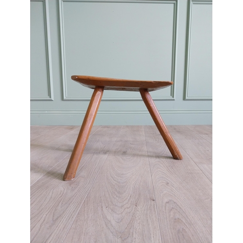 64 - 19th. C Irish painted elm three legged stool {35 cm H x 38 cm W x 26 cm D}.