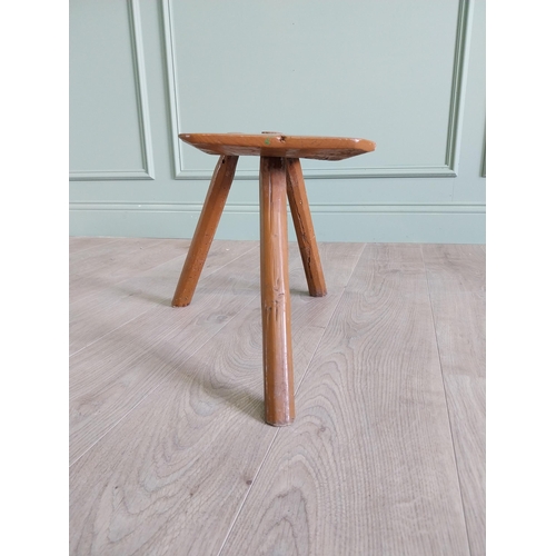 64 - 19th. C Irish painted elm three legged stool {35 cm H x 38 cm W x 26 cm D}.