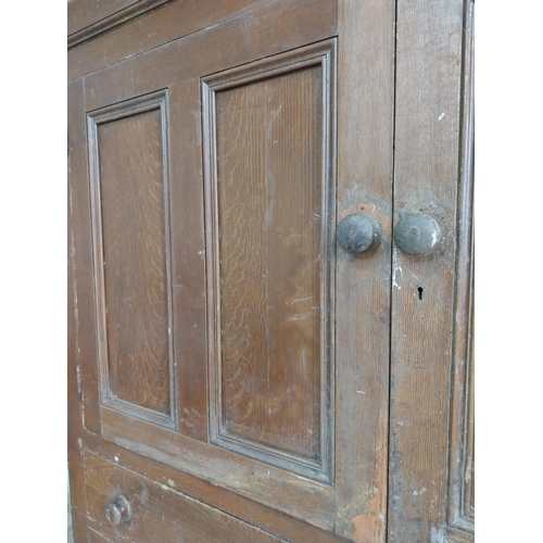 213 - 19th C. Irish scumbled pine kitchen cupboard with two panelled doors and two short drawers over two ... 