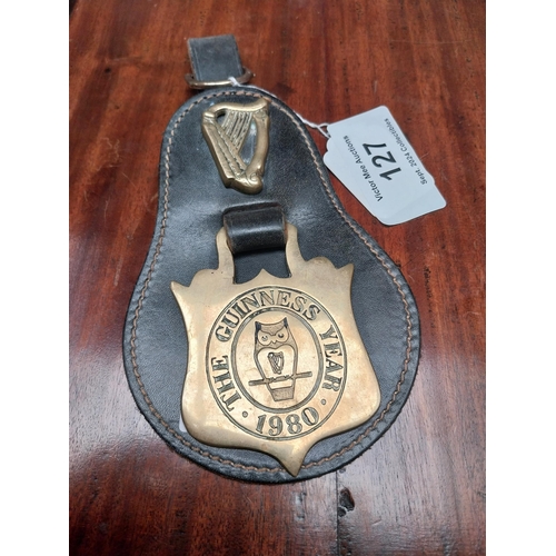 127 - Guinness Year 1980 badge and leather strap. {23 cm H x 12 cm W}