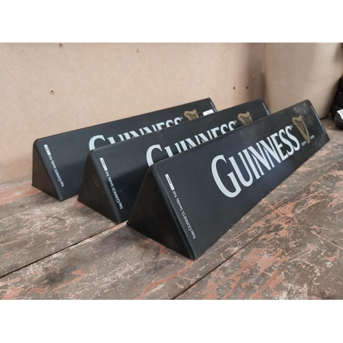 1289 - Three Guinness counter signs. {9 cm H x 45 cm W}.