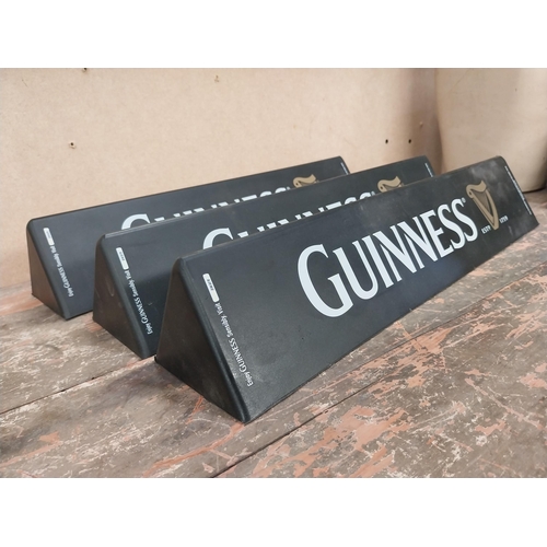 1289 - Three Guinness counter signs. {9 cm H x 45 cm W}.