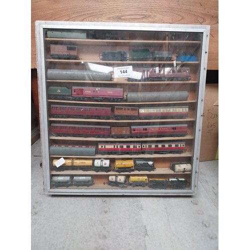 144 - Cased collection of 1950's railway carriages and engines.  {62 cm x 58 cm W x 8 cm D}.