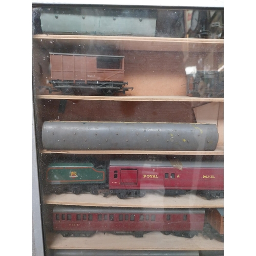 144 - Cased collection of 1950's railway carriages and engines.  {62 cm x 58 cm W x 8 cm D}.