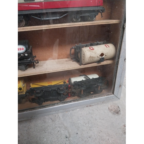 144 - Cased collection of 1950's railway carriages and engines.  {62 cm x 58 cm W x 8 cm D}.