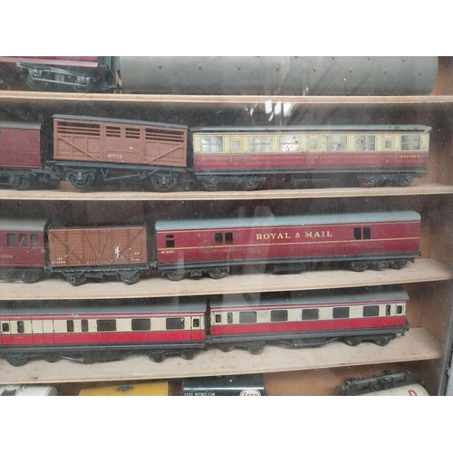 144 - Cased collection of 1950's railway carriages and engines.  {62 cm x 58 cm W x 8 cm D}.