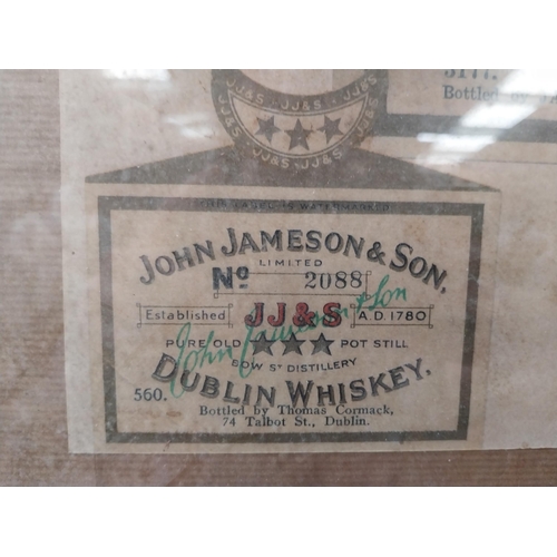 191 - Framed collection of three John Jameson and John Powers Whiskey labels. {44 cm H x 35 cm W}.