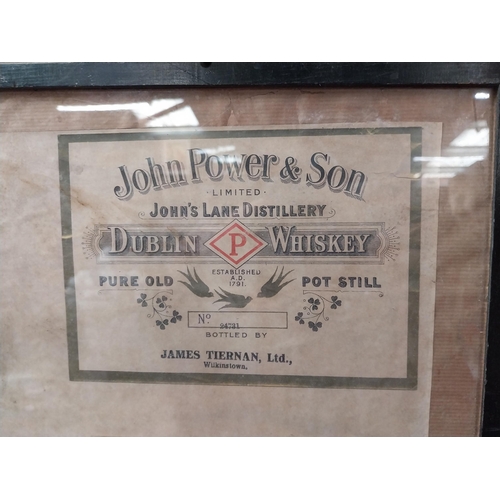 191 - Framed collection of three John Jameson and John Powers Whiskey labels. {44 cm H x 35 cm W}.