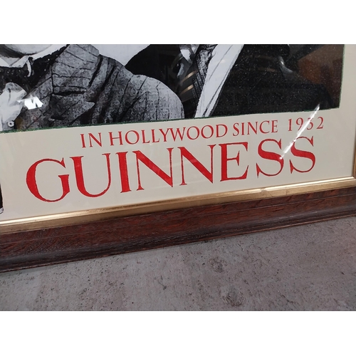 1306 - Guinness in Hollywood since 1932 framed advertising print. {59 cm H x 77 cm W}.