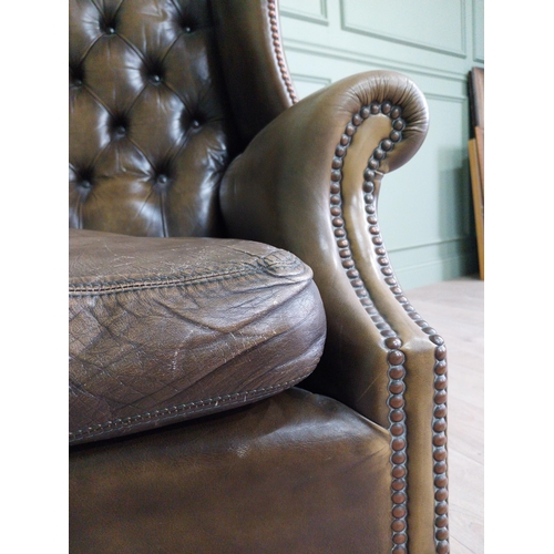 1284 - Pair of 1950s hand dyed green leather wingback with deep buttoned back and brass studs raised on squ... 