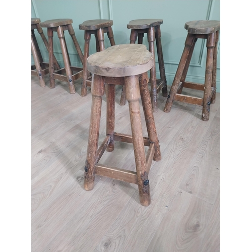 1055 - Set of six vintage pine counter stools with saddle seat raised on circular splayed legs {68 cm H x 6... 