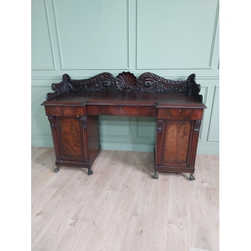 107 - Irish profusely carved mahogany sideboard with gallery decorated with central shell raised on brass ... 