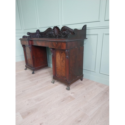 107 - Irish profusely carved mahogany sideboard with gallery decorated with central shell raised on brass ... 