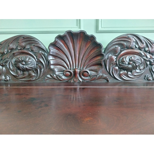 107 - Irish profusely carved mahogany sideboard with gallery decorated with central shell raised on brass ... 