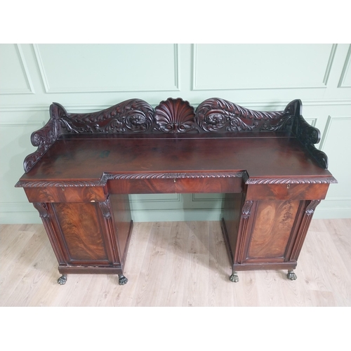 107 - Irish profusely carved mahogany sideboard with gallery decorated with central shell raised on brass ... 