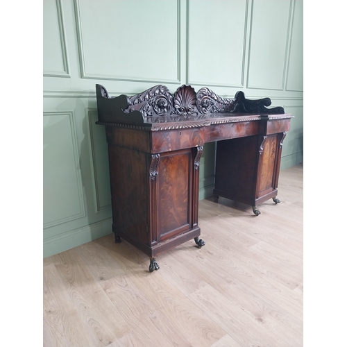 107 - Irish profusely carved mahogany sideboard with gallery decorated with central shell raised on brass ... 